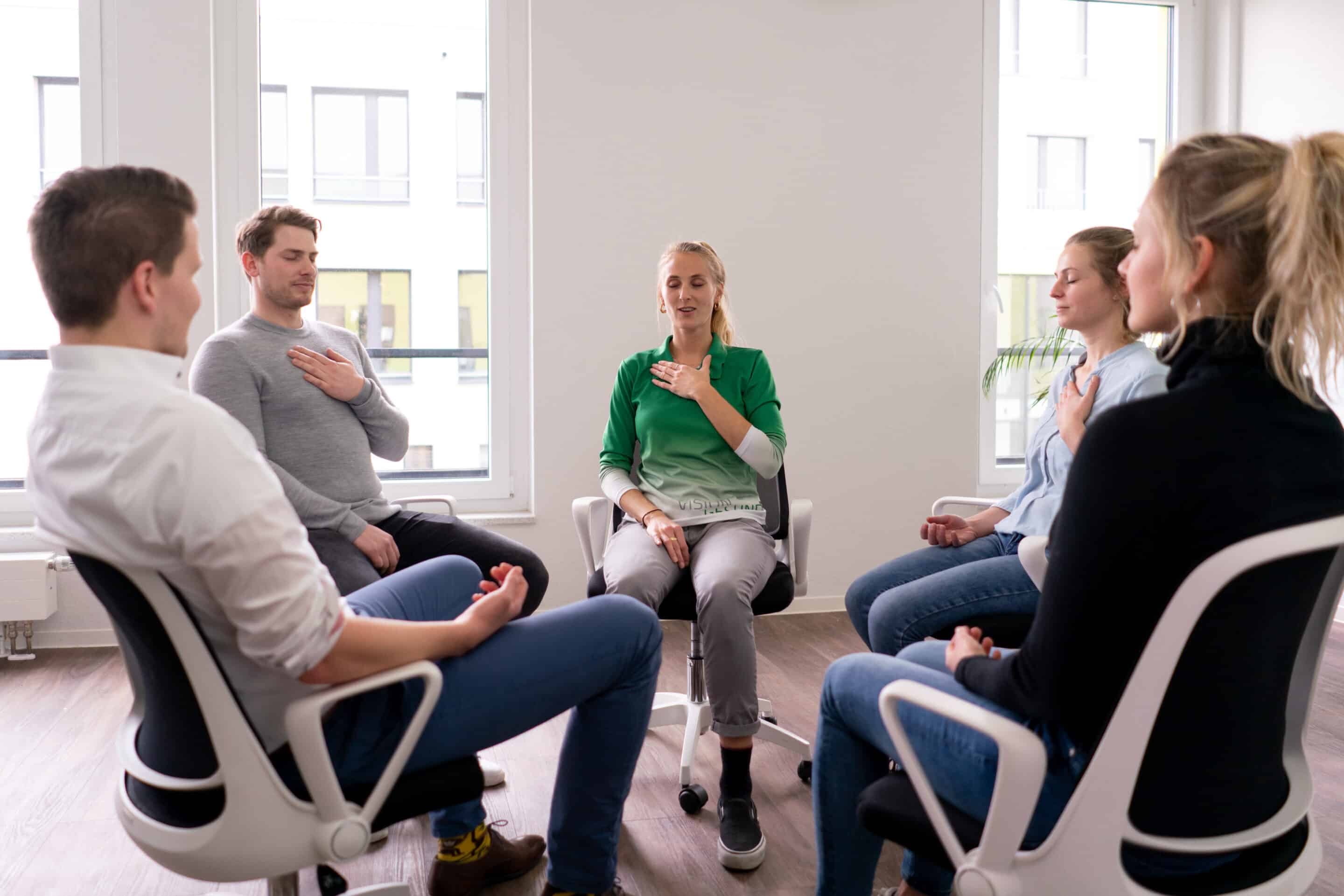 Teilnehmende sitzen im Stuhlkreis und nehmen an einem moderierten BGF‑Workshop zur Förderung von Gesundheit und Austausch teil.